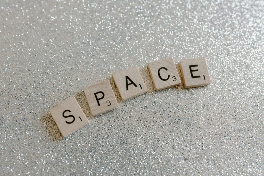 Wooden Scrabble tiles spelling 'Space' on a glittering background, perfect for concepts and ideas.
